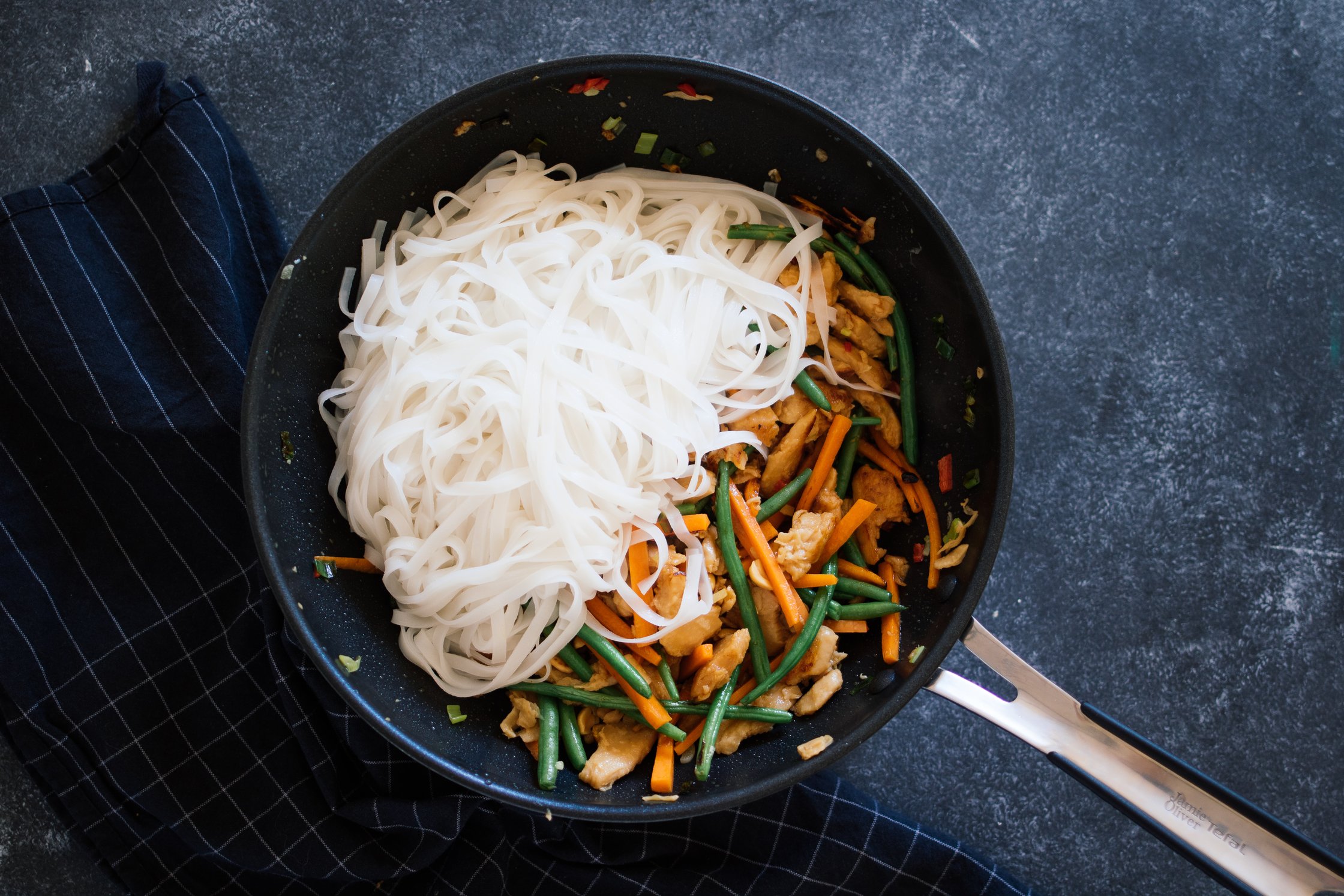 rice noodles and veggies in a wok