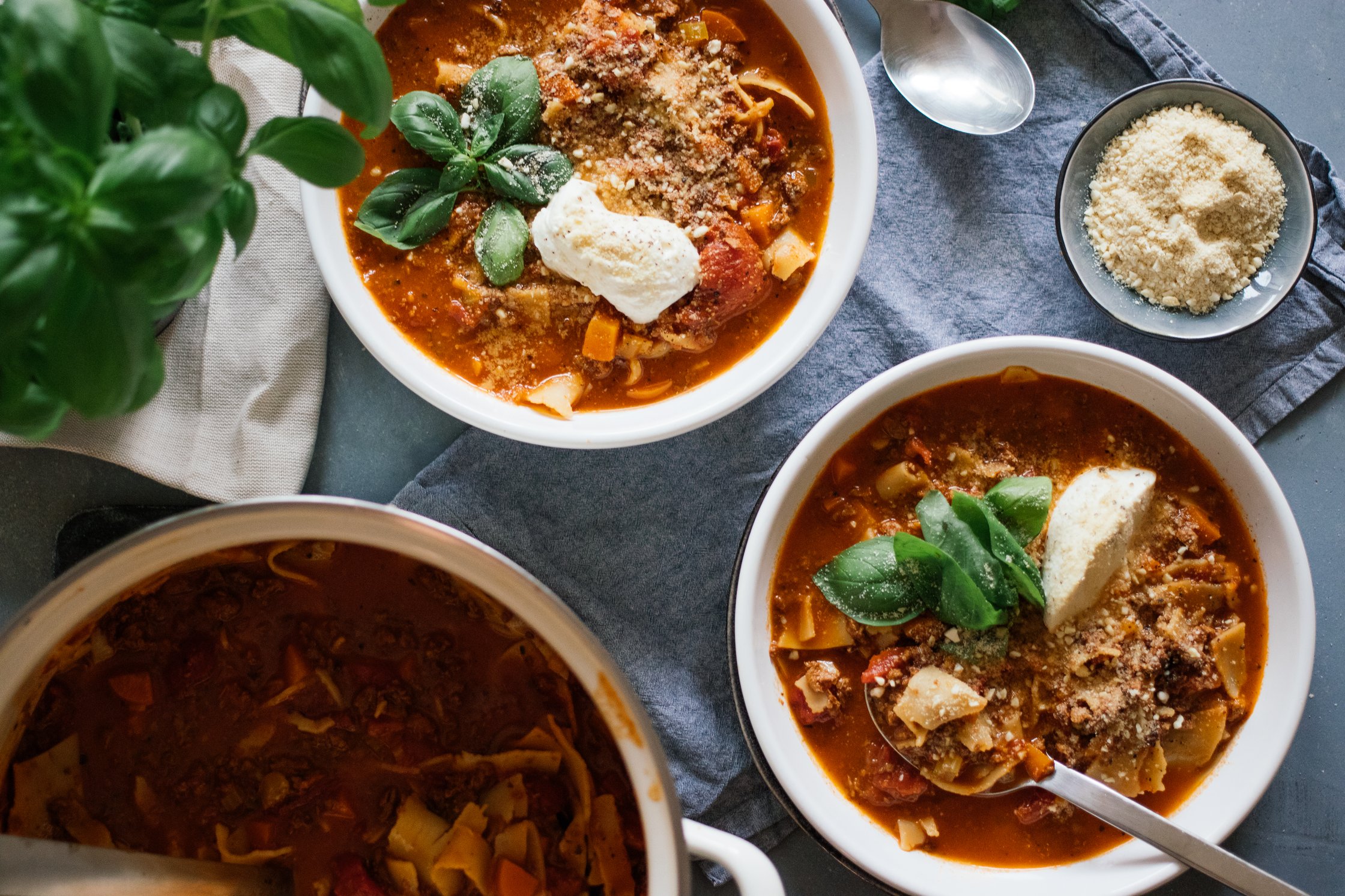 vegan lasagna soup served on the table with vegan parmesan