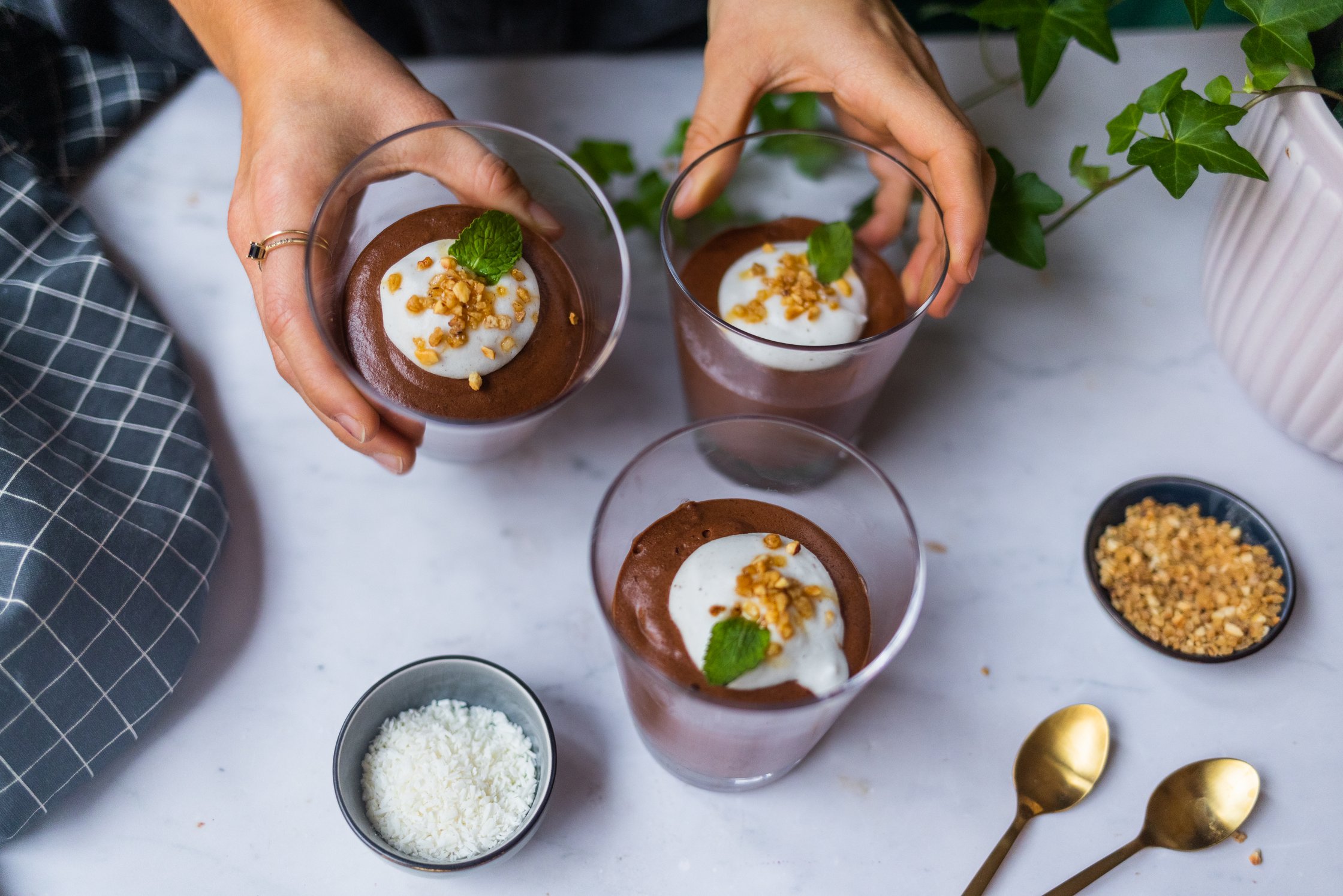 Vegane Mousse au Chocolat mit Kokossahne vor einem hellen Hintergrund.
