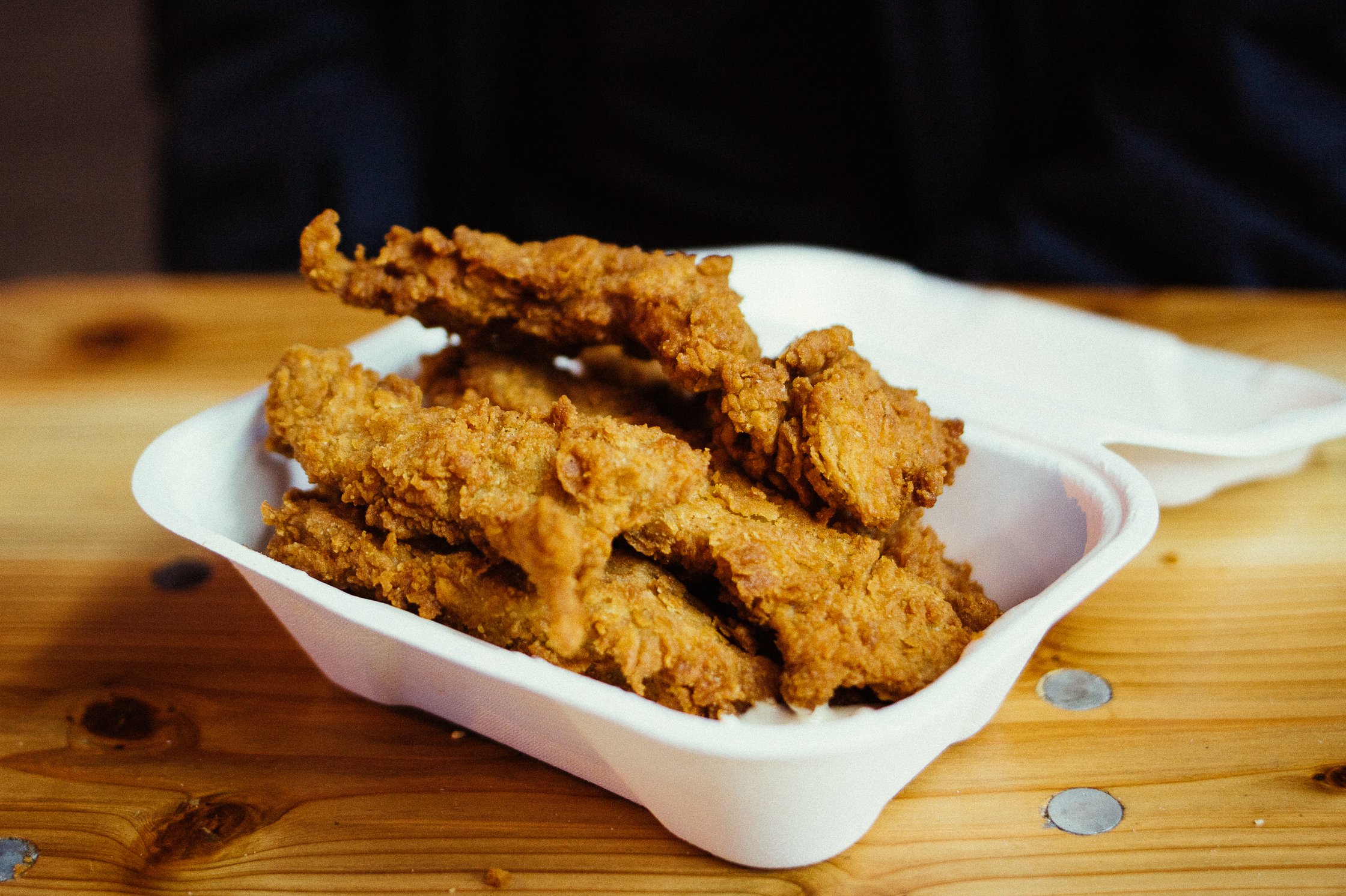 vegane Chicken Finger liegen in einer weißen Box auf dem Tisch
