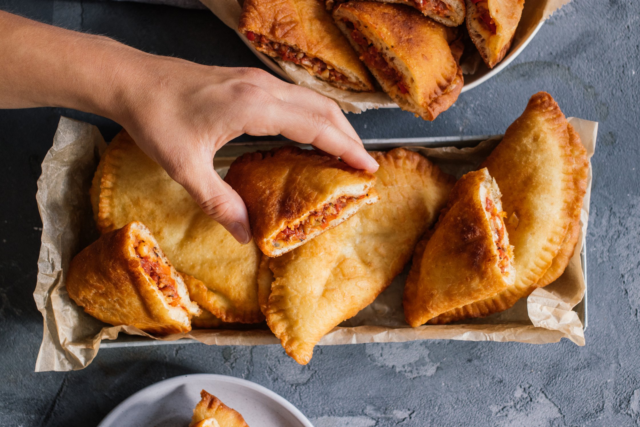 hand grabbing vegan panzerotti