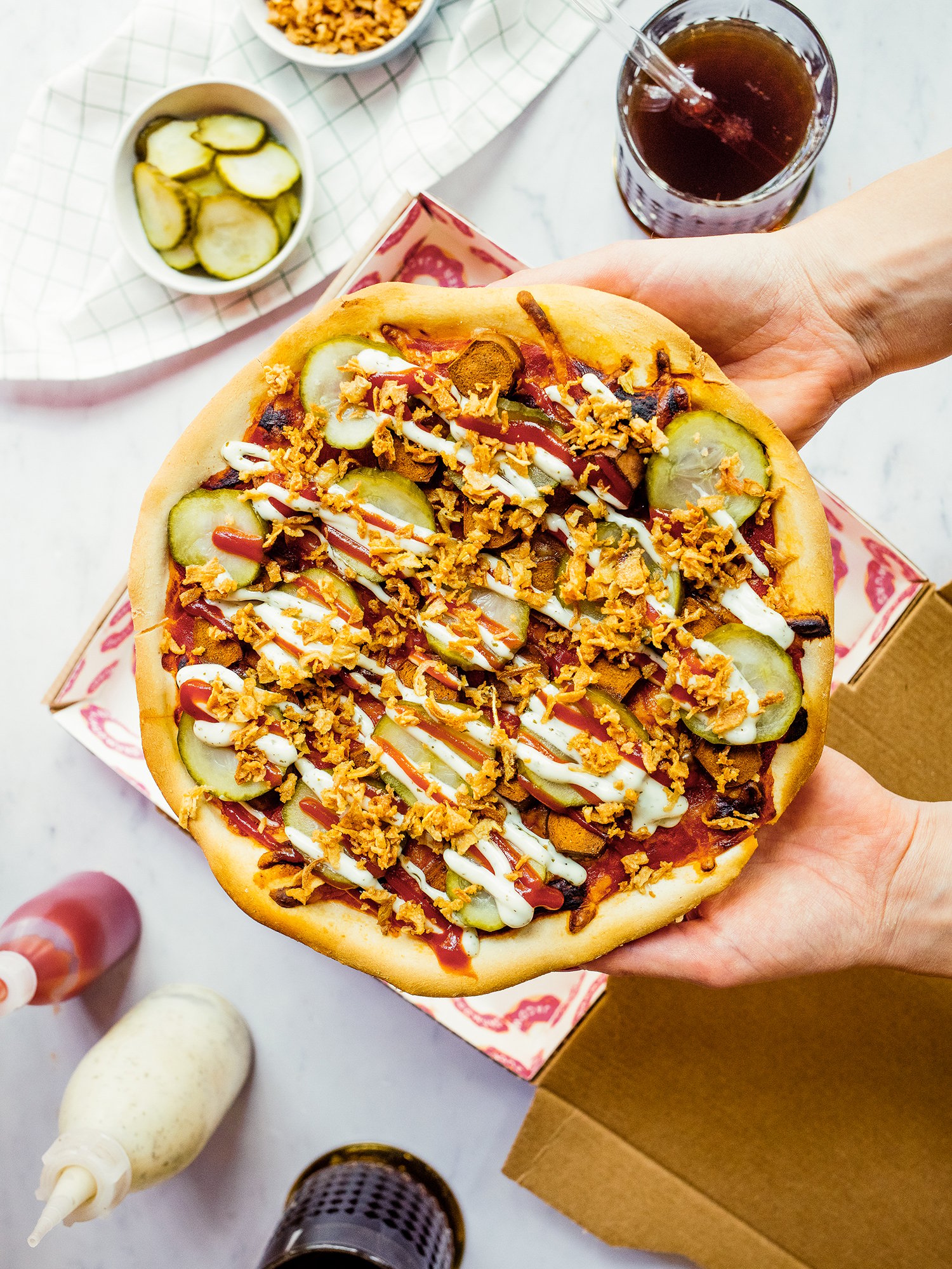 vegane Hot Dog Pizza wird gehalten