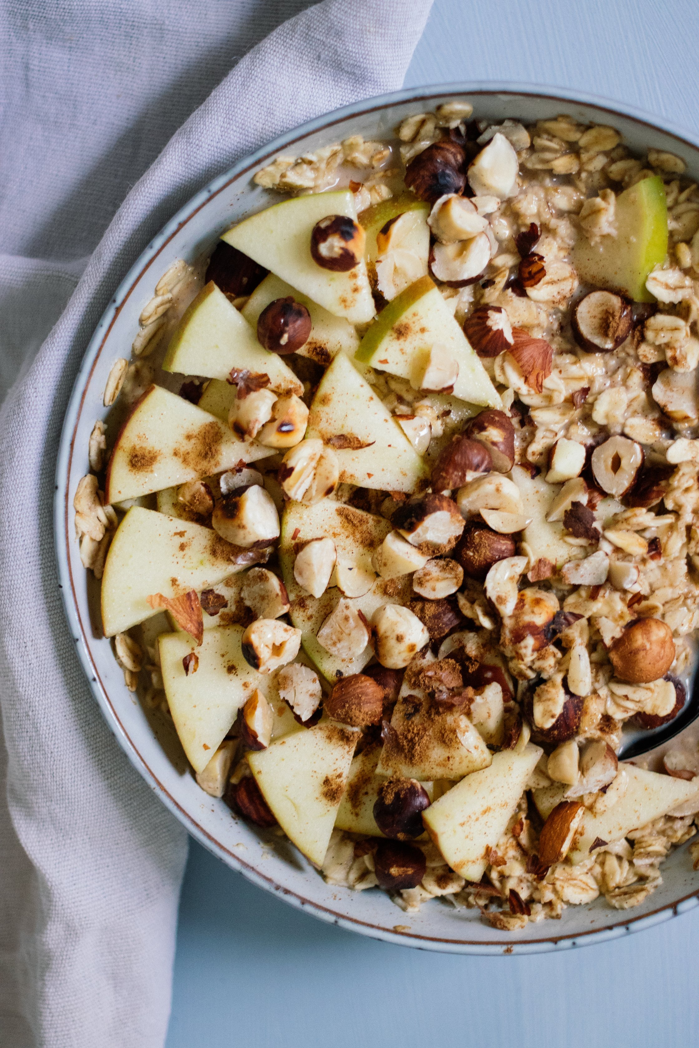 veganes oatmeal mit apfel und haselnüssen von oben fotografiert