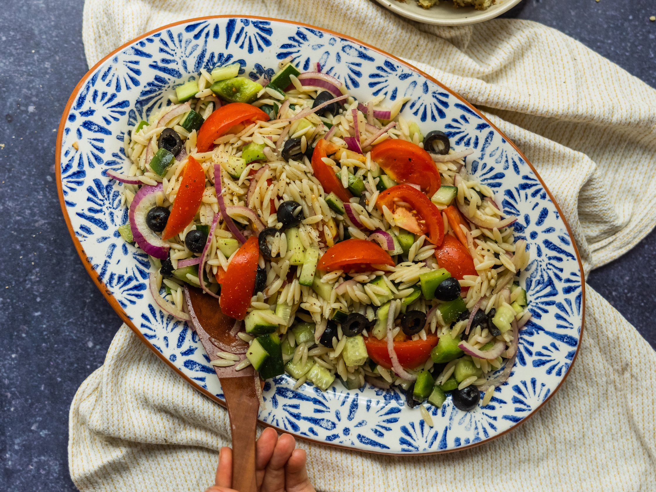 Griechischer Salat mit Oliven, Tomaten, Nudeln, Gurke und roten Zwiebeln