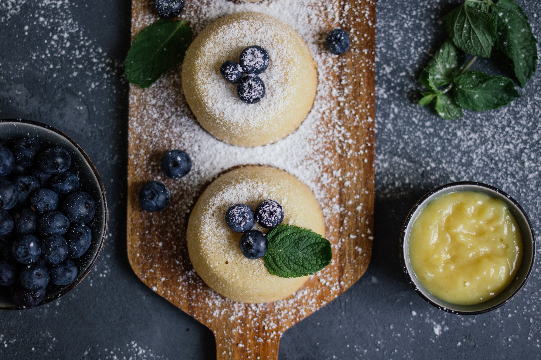 vegan lemon cakes are served on a wooden plate