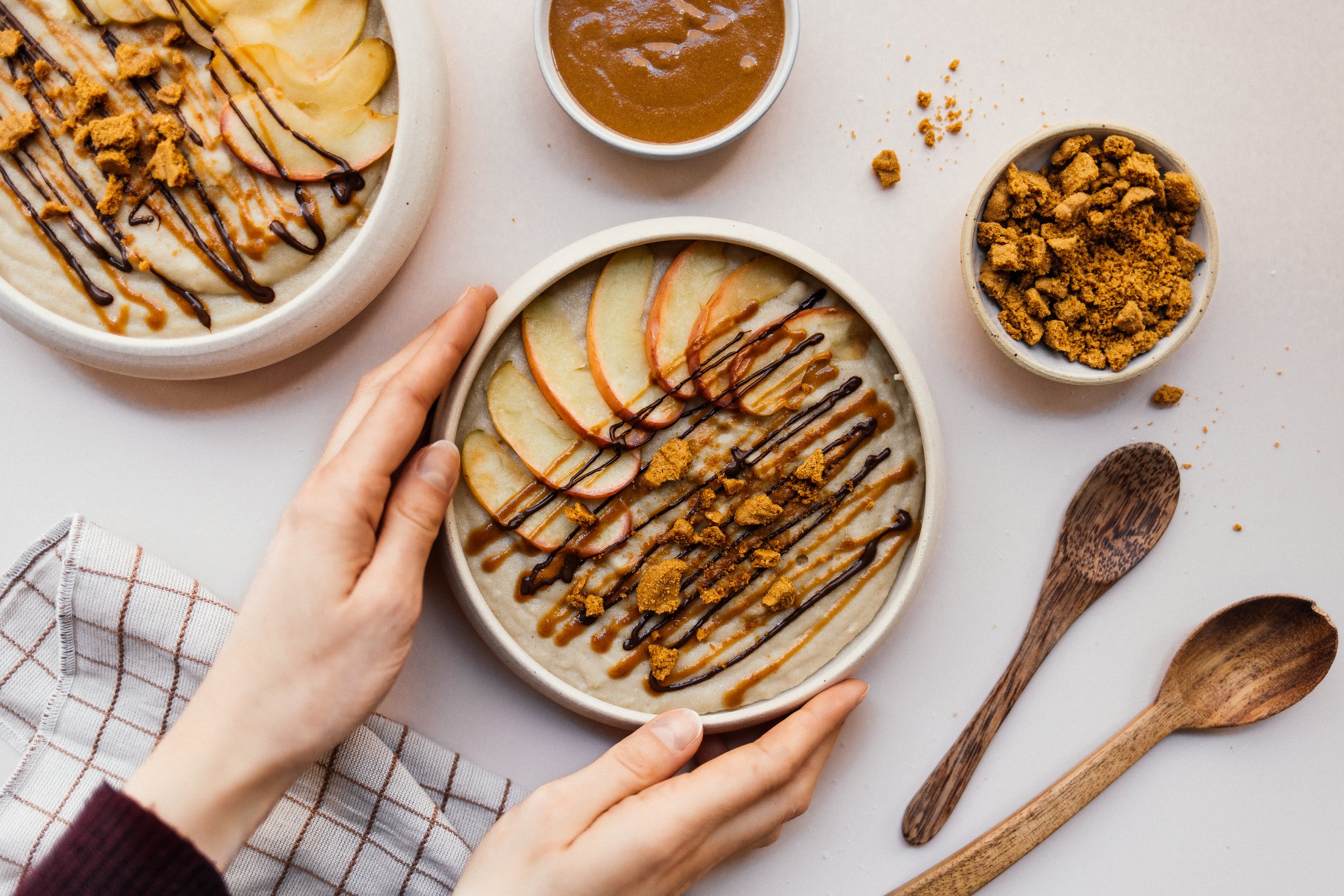 eine Schüssel mit veganem Biscoff-Grießbrei in den Händen
