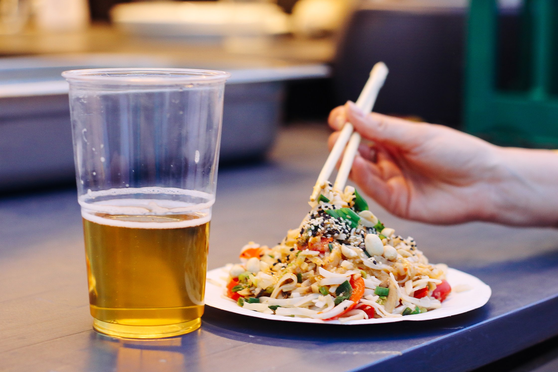 ein Bier steht neben einem Teller mit Glasnudelsalat