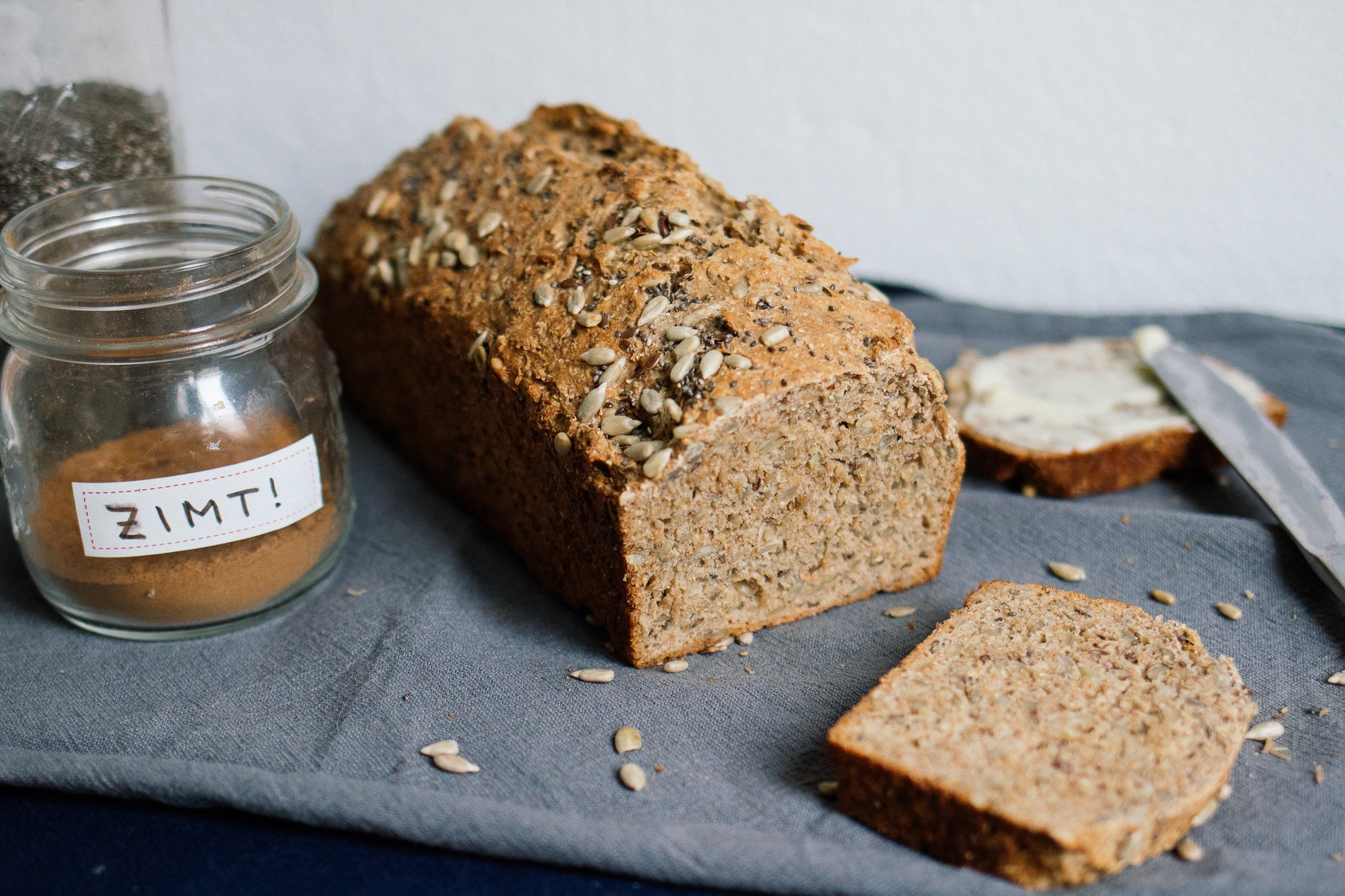 sunflower chia bread next to a jar of cinnamon