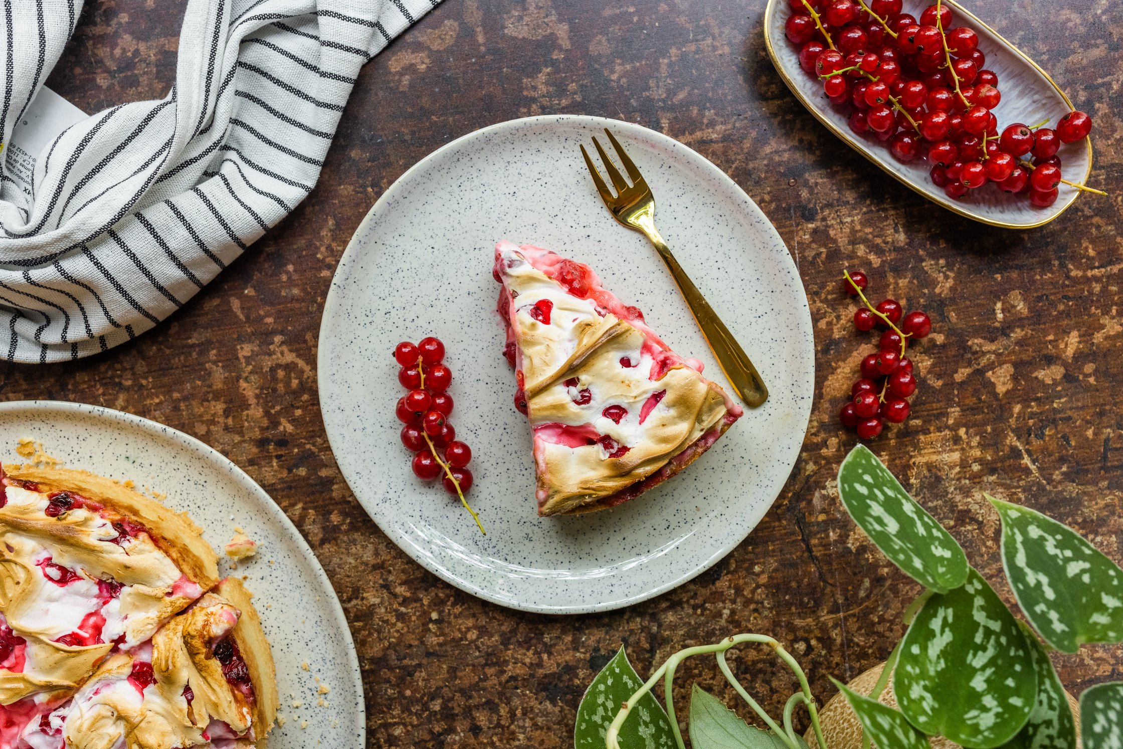 A piece of a Red Currant Meringue Cake on a plate with a fork