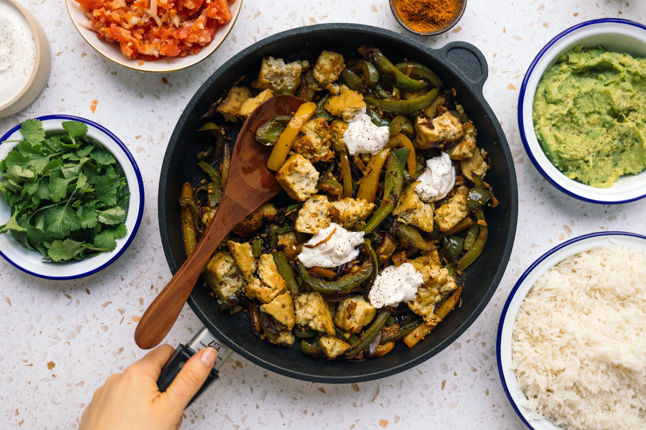 tofu fajitas served with vegan sour cream, guacamole, rice, salsa, and cilantro