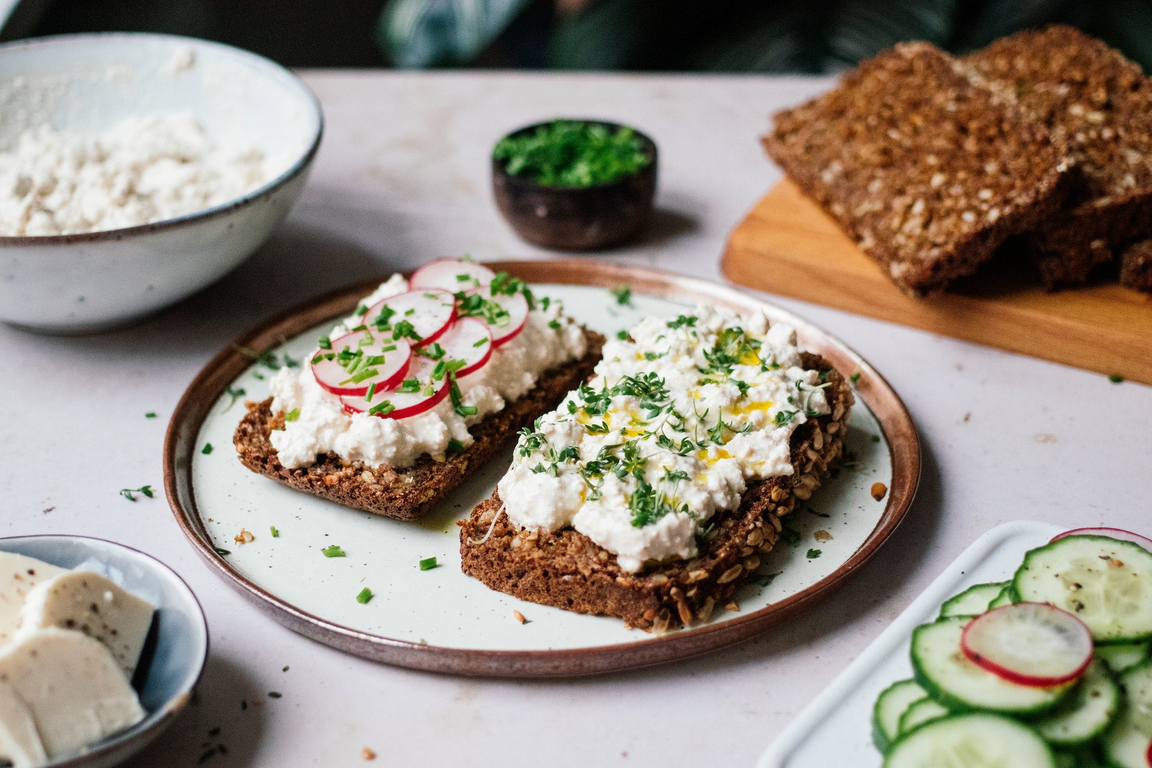 veganer körniger frischkäse auf zwei scheiben brot