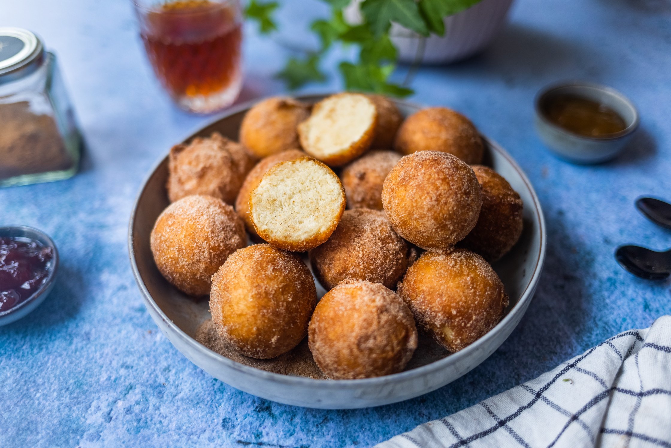 Vegan curd doughnuts roll out of a white bag.
