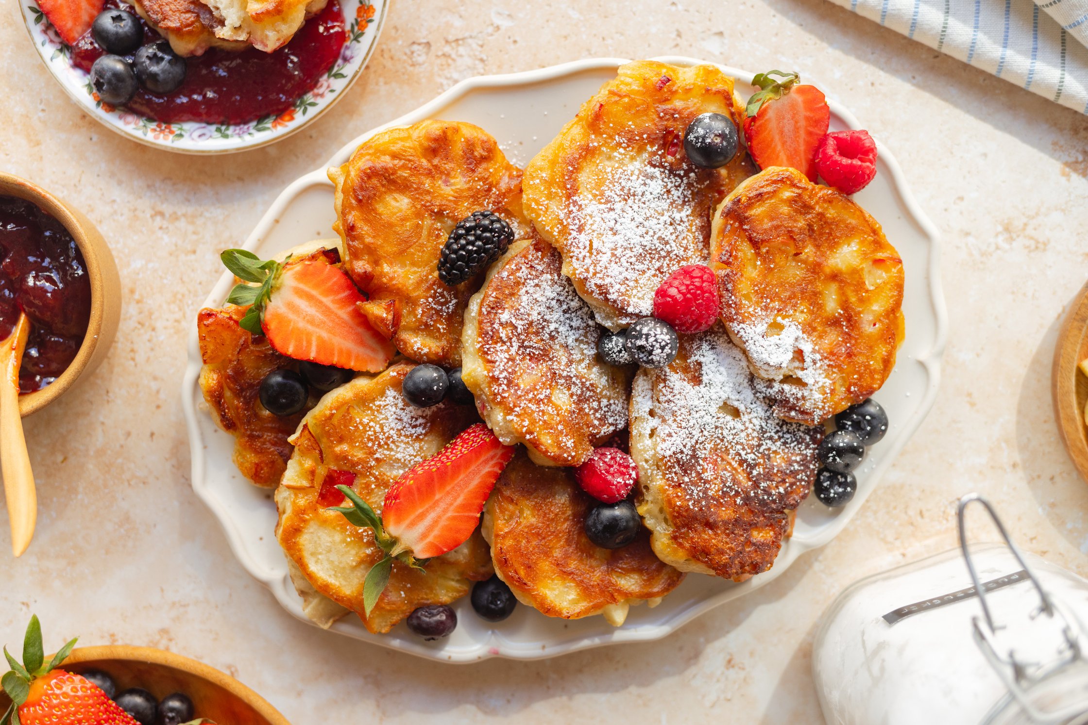 vegane Hefepfannkuchen dekoriert mit Puderzucker und frischen Beeren