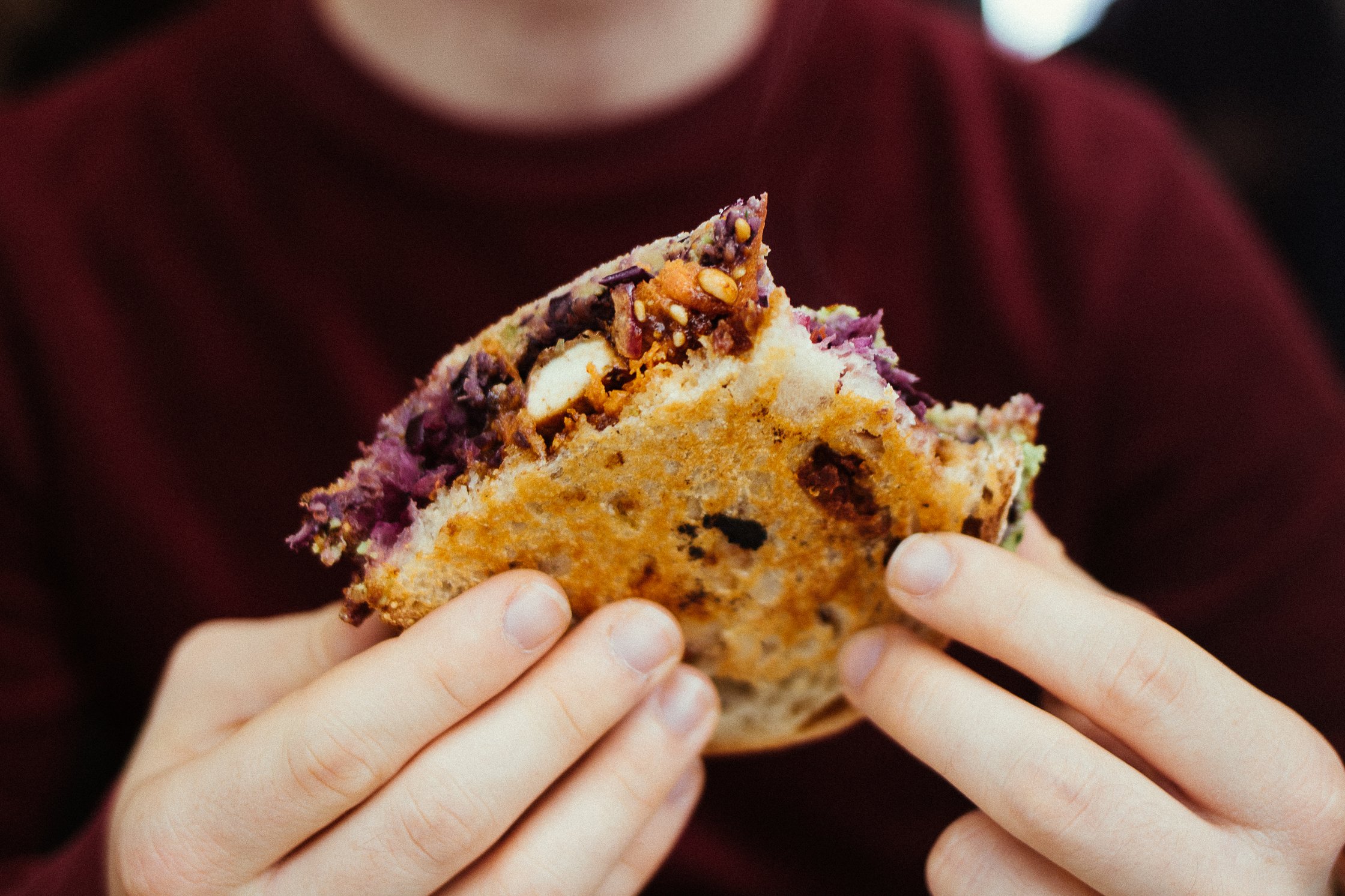 ein Junge hält ein Frühstücks-Sandwich in den Händen