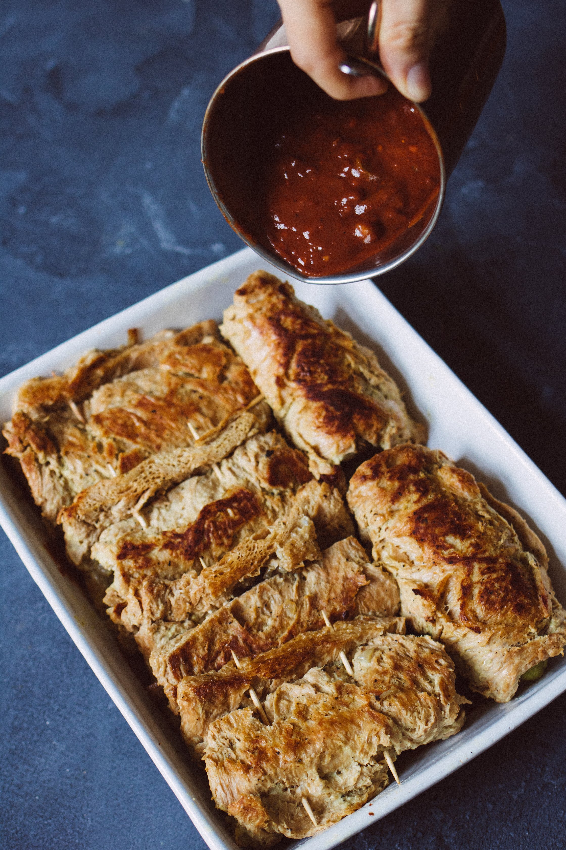 sauce is tossed on vegan soy steaks