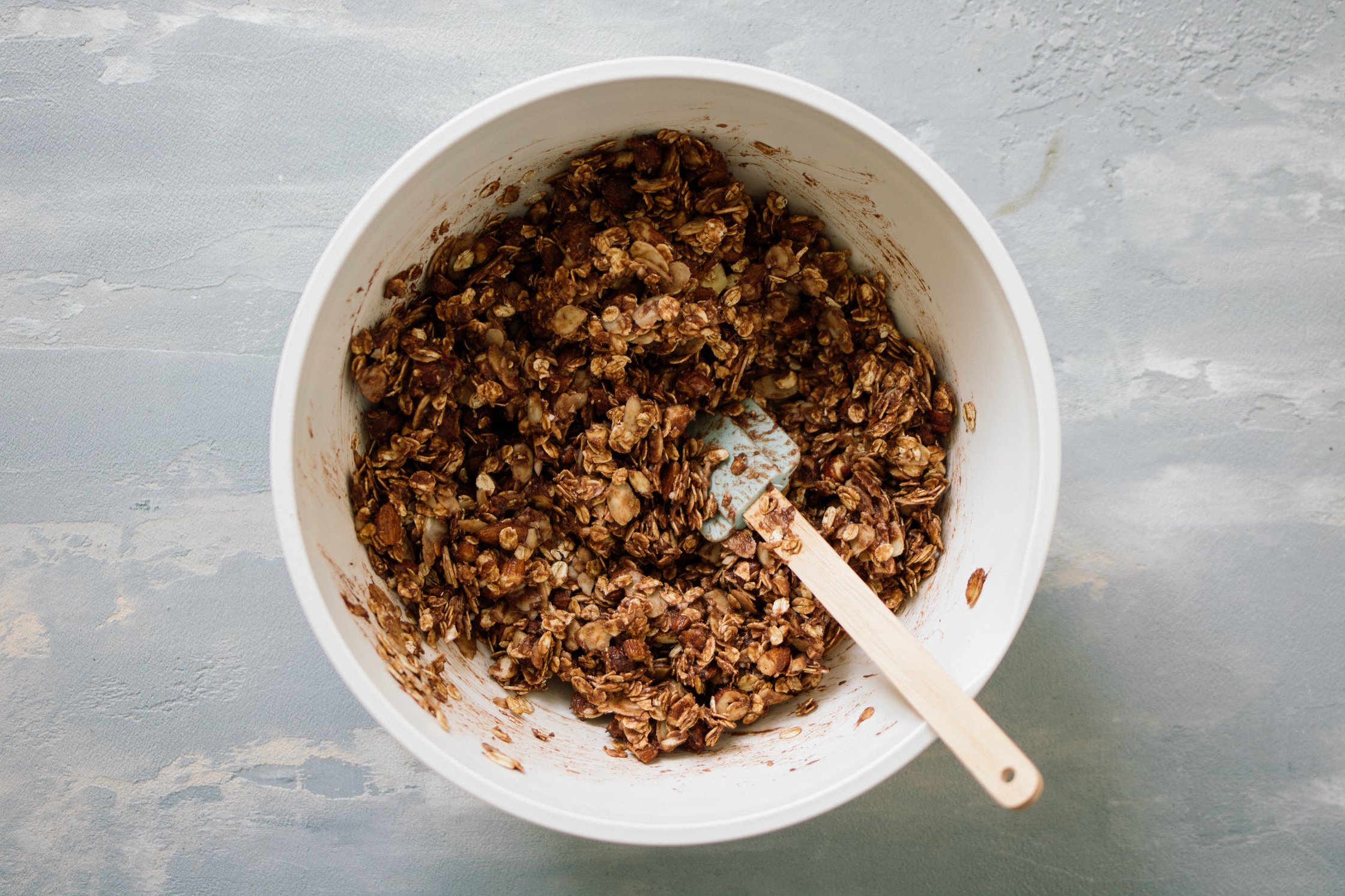 Granola in weißer Schüssel mit Milch