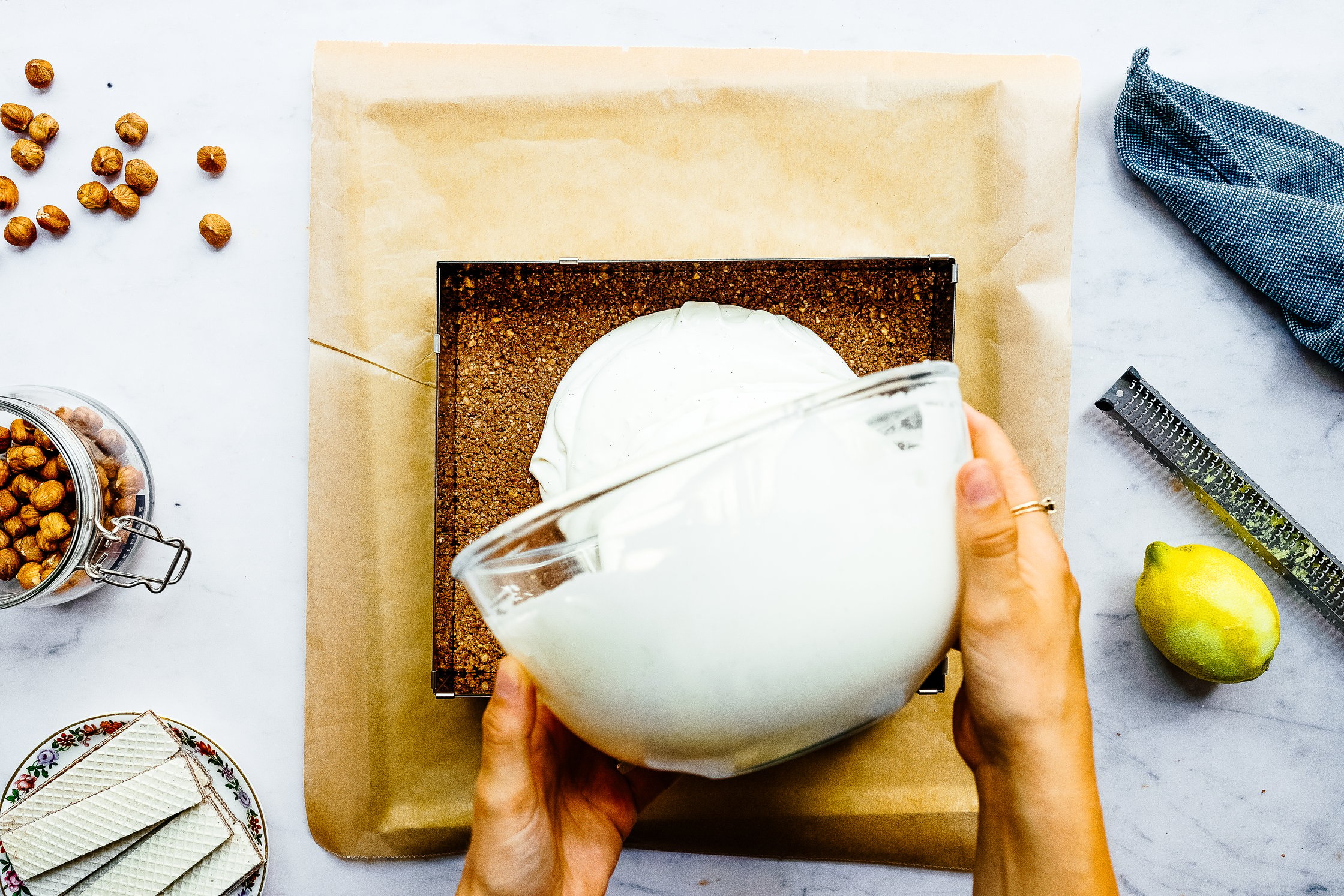 pouring cheesecake creme on a hazelnut base