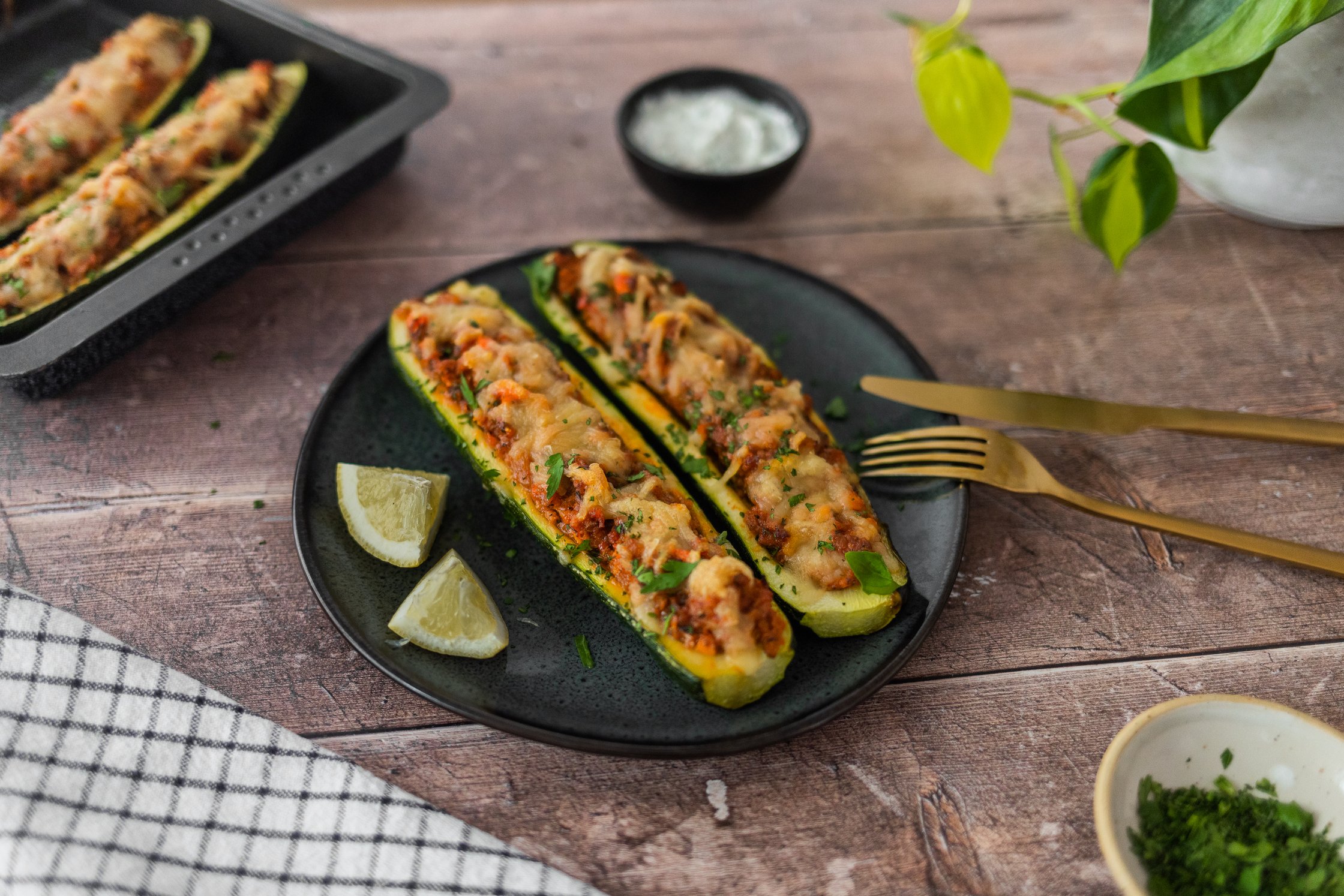 Vegane gefüllte Zucchini auf einem Teller angerichtet.