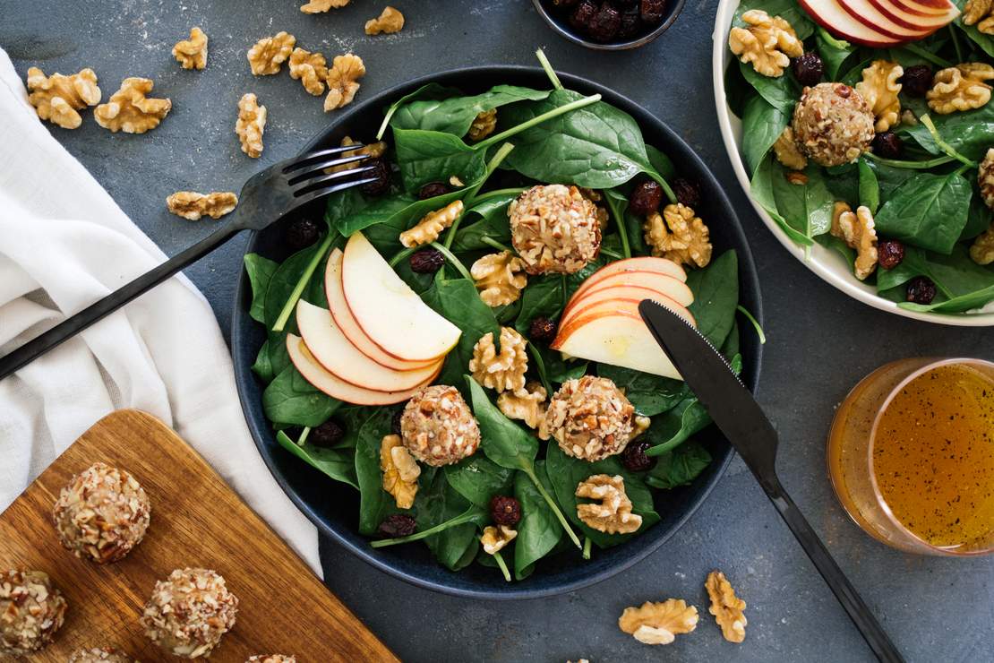 R129 vegan cheese balls on a salad with apple & cranberry